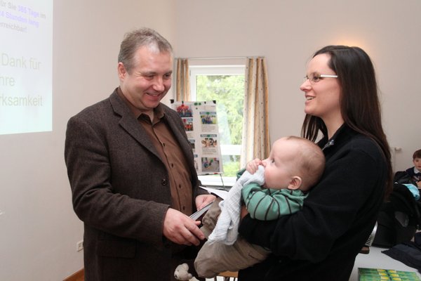 Bürgermeister Dollacker überreicht das Baby-Begrüßungsgeld der Gemeinde.